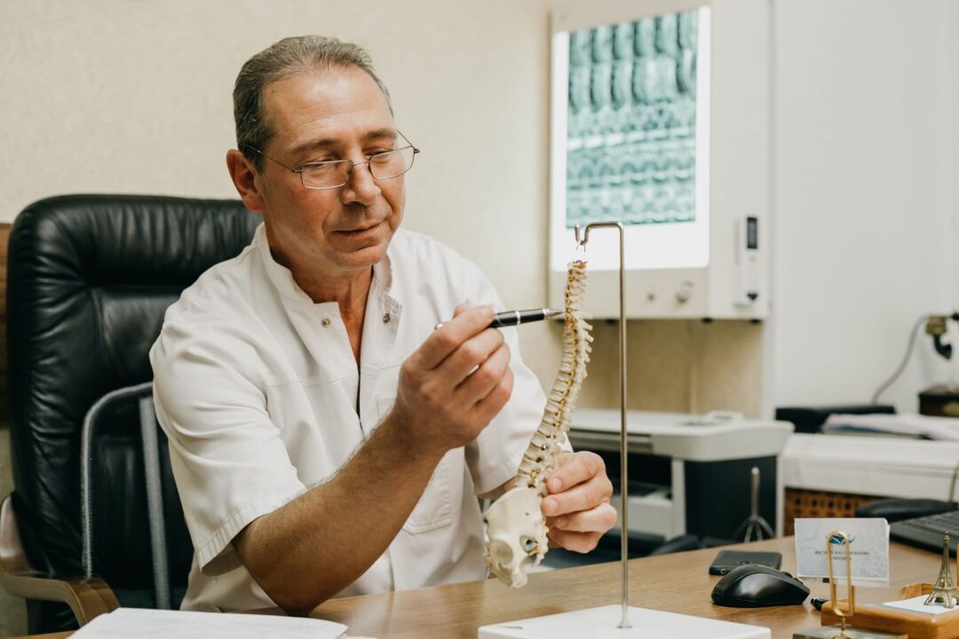 O médico explica as características do tratamento da osteocondrose da coluna torácica
